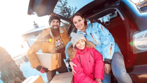 family smiling during winter with moving boxes