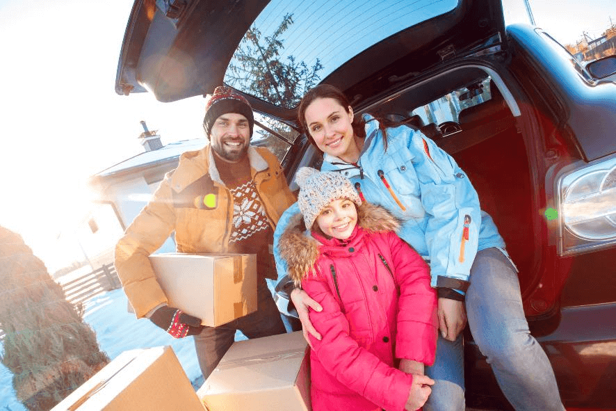 family smiling during winter with moving boxes