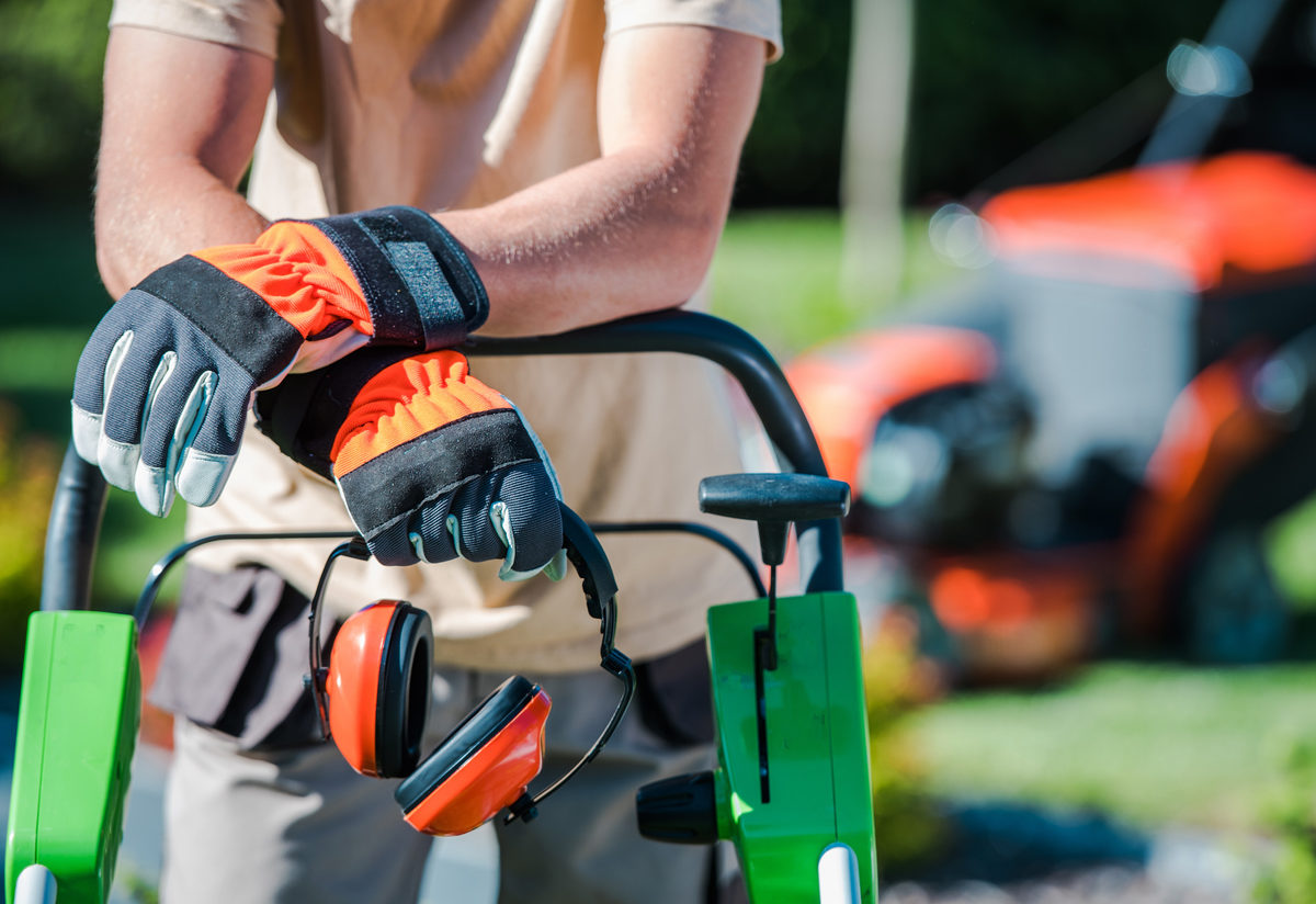 landscaper leaning on lawnmower