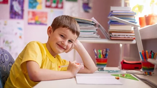 Child smiling at their homeschool desk