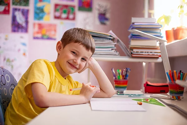 Child smiling at their homeschool desk