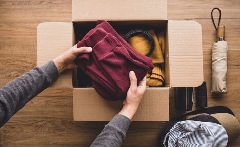 folded sweatshirts being placed into a box