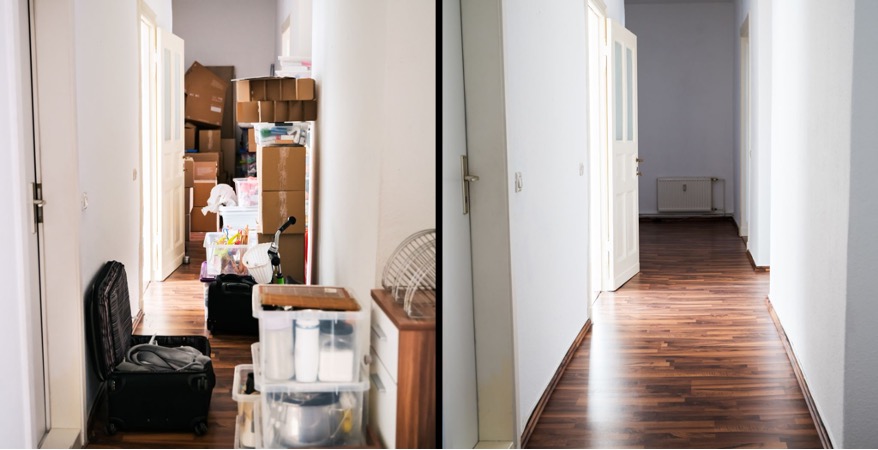 collection of stacked boxes in a hallway. There is also an open suitcase in the foreground of the photo.