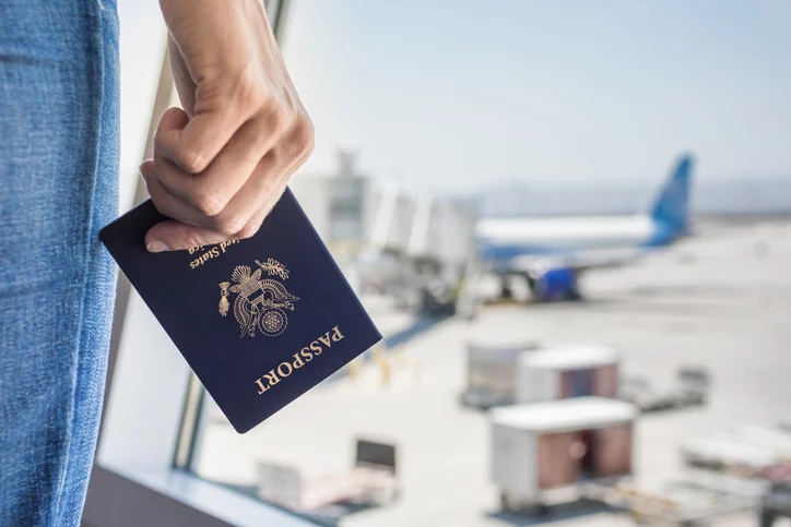 woman holding a passport, waiting at the airport for a flight