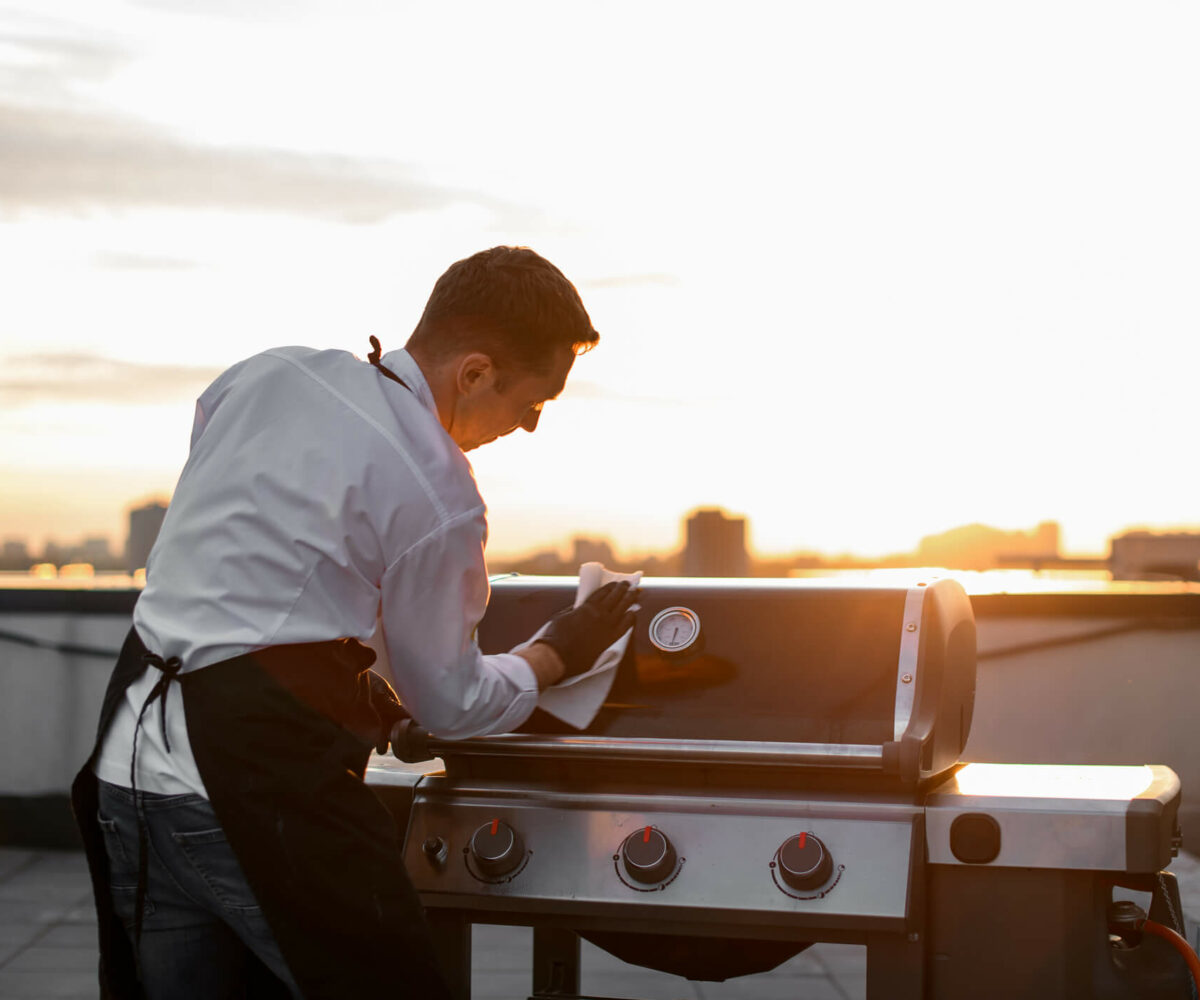 man cleaning a grill with a cloth