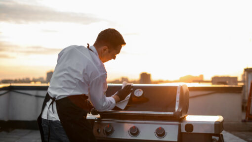 man cleaning a grill with a cloth