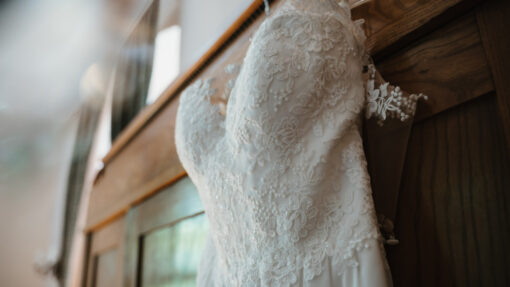 a white wedding dress hanging on the door of a closet