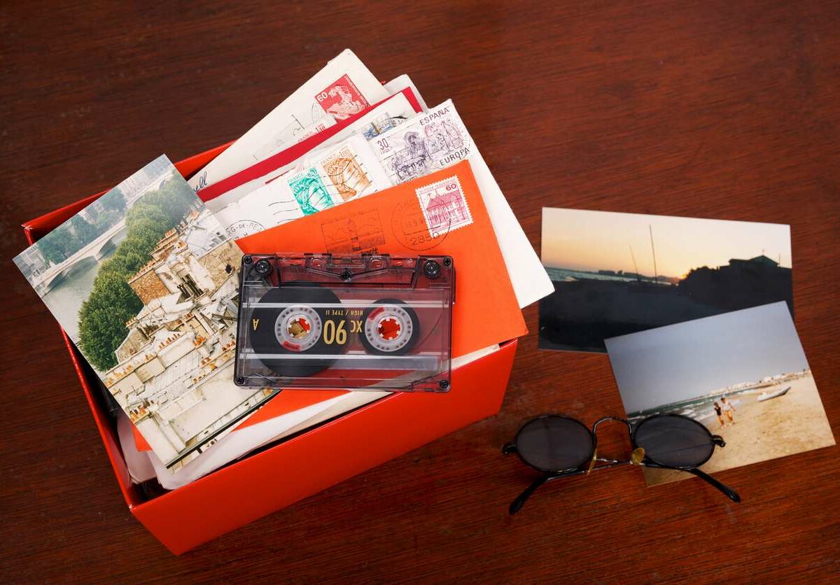 A box of photos sits on a table with photographs spread around