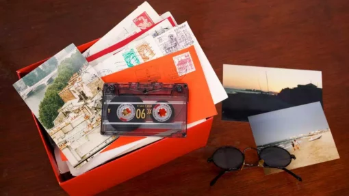 A box of photos sits on a table with photographs spread around