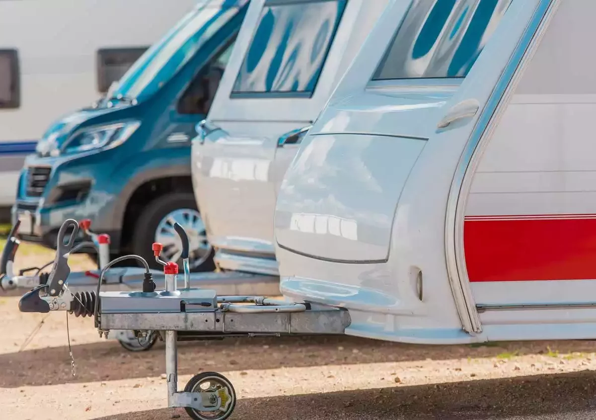 RVs are parked in a line at a storage facility