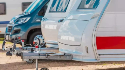 RVs are parked in a line at a storage facility