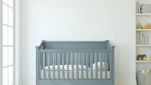 A blue baby crib sits against a white wall in a residential space.