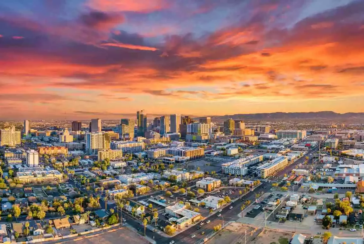 A photo of the Phoenix skyline with a blue, purple, orange, and yellow sunset in the background.