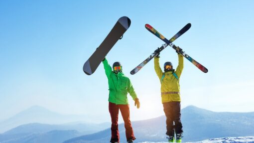 Two men holding a ski and snowboard at the top of a mountain.