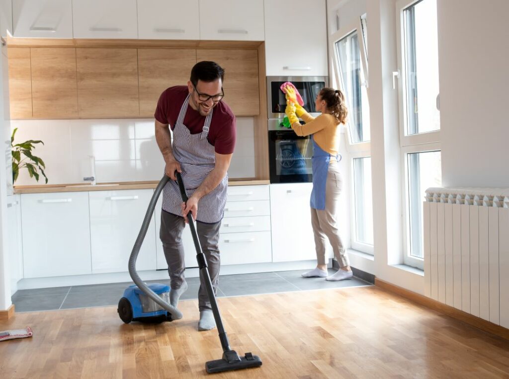 A man and woman spring clean their home together.
