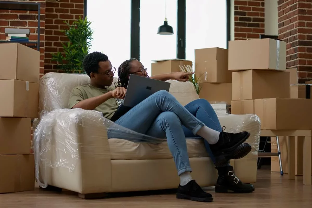 A couple takes a break on the couch while moving.