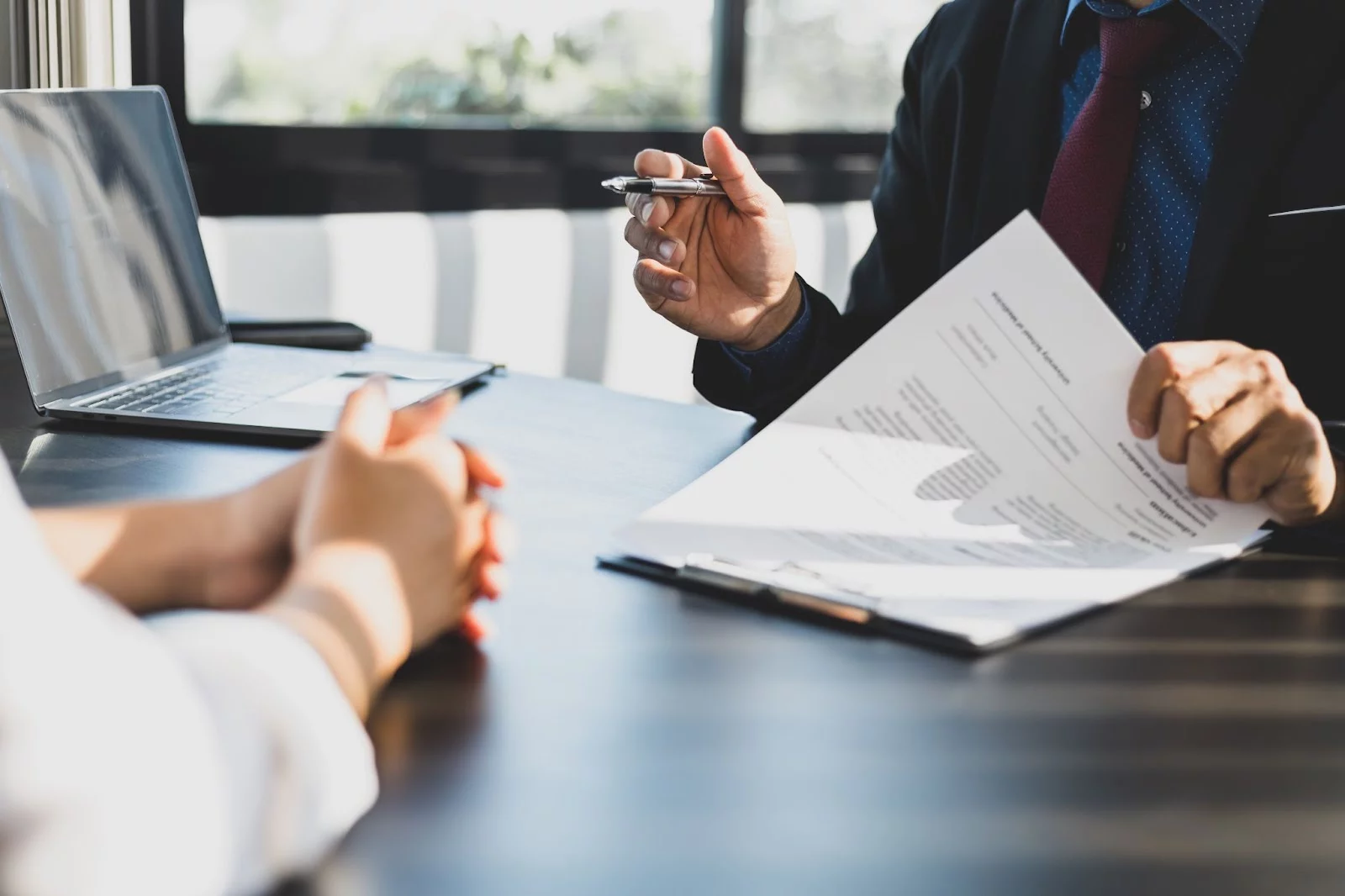 An insurance agent walks through a policy with a client, reading through the physical forms.