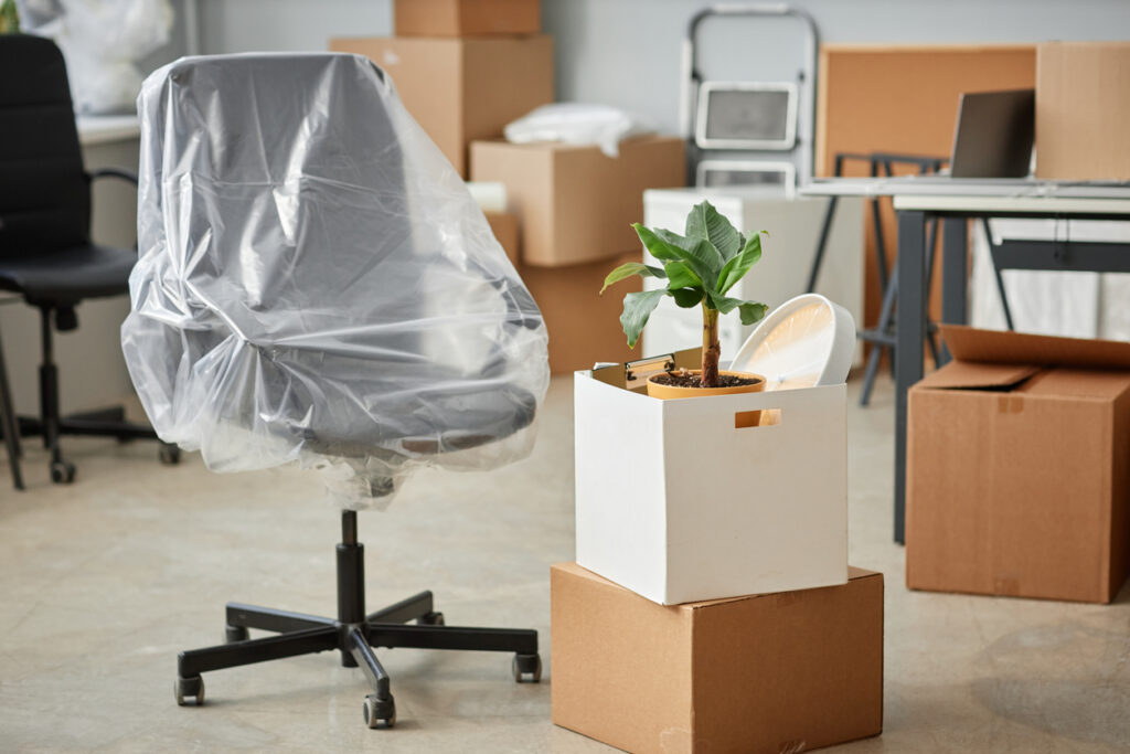 Boxes and extra office furniture being packed for storage.