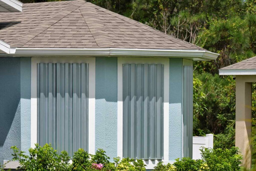 Steel storm shutters installed over house windows for protection against a hurricane.