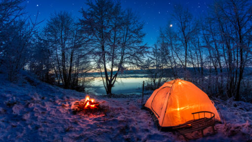 A camp and campfire at a lovely winter camping site.