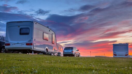 Several RVs and cars parked at an RV campsite.